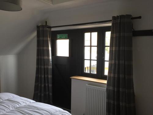 a bedroom with a bed and a window with curtains at Bishop Percys House in Bridgnorth