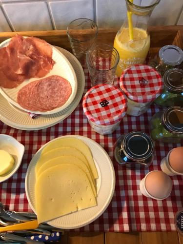 een tafel met borden met voedsel op een geruite tafeldoek bij De Kempse Hoeve B&B in Boxtel