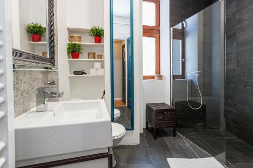 a bathroom with a sink and a toilet and a shower at Designer Apartment Eclectica in Belgrade