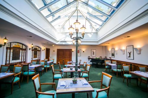 a dining room with tables and chairs and a skylight at Hotel Opera in Sopot