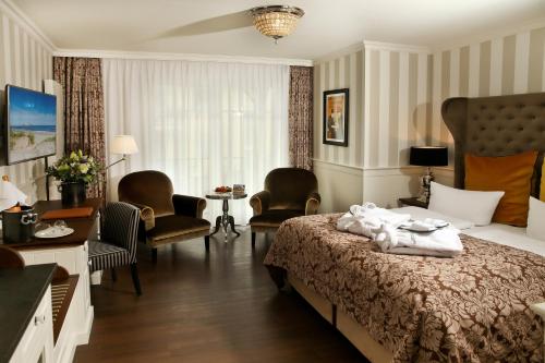 a hotel room with a bed and chairs and a table at Europa Hotel Kühlungsborn in Kühlungsborn