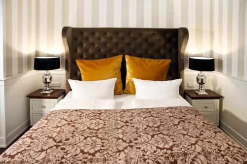 a bedroom with a large bed with two lamps at Europa Hotel Kühlungsborn in Kühlungsborn