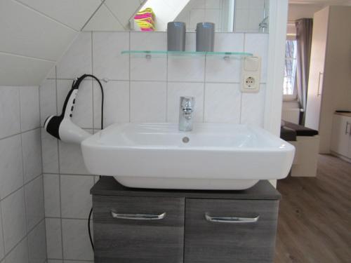 ノルダーナイにあるStrandflieder Backbordのバスルーム(白い洗面台、鏡付)