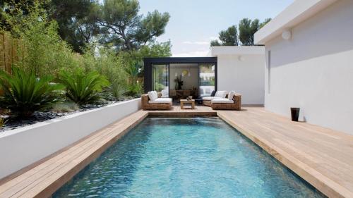 une piscine dans l'arrière-cour d'une maison avec une terrasse en bois dans l'établissement Casa Lulli, à Cassis