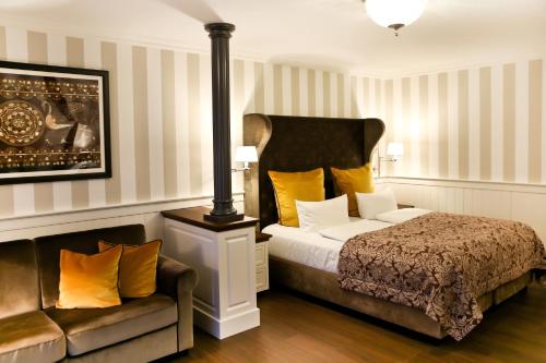 a bedroom with a bed and a couch in it at Europa Hotel Kühlungsborn in Kühlungsborn