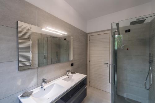 La salle de bains est pourvue d'un lavabo et d'une douche. dans l'établissement Villa Bianca, à Varenna