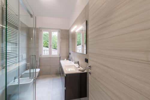 a bathroom with a sink and a toilet and a mirror at Villa Bianca in Varenna