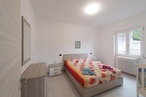 a bedroom with a bed and a desk and a window at Villa Bianca in Varenna