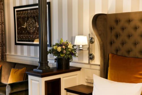 a hotel room with a couch and a table with flowers at Europa Hotel Kühlungsborn in Kühlungsborn
