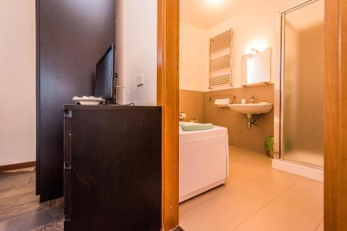a bathroom with a sink and a toilet and a television at B&B Le Dune - Self Check in in Lascari