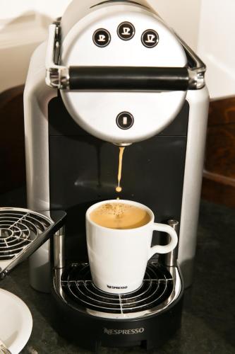 a coffee maker is making a cup of coffee at Europa Hotel Kühlungsborn in Kühlungsborn