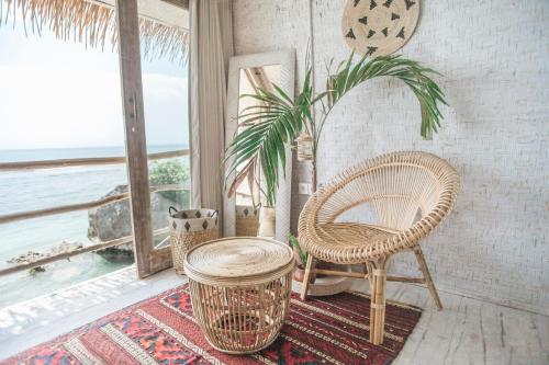 
a wooden chair sitting in front of a large window at Dreamsea Bali in Uluwatu

