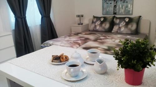 Apartman Marja - Studio في نجيفيش: طاولة مع كوبين من القهوة وسرير