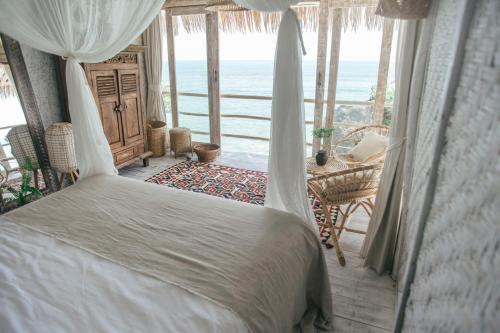 
a bedroom with a bed and a table at Dreamsea Bali in Uluwatu

