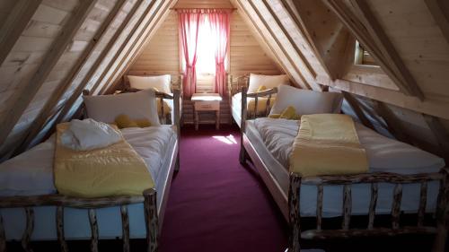 two beds in a small room with a window at Bed & Breakfast KUM in Sokolac