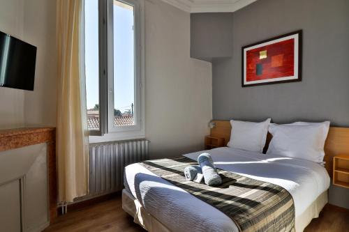 une chambre avec un lit avec un ours en peluche dessus dans l'établissement Hotel La Villa Florida, à Bandol