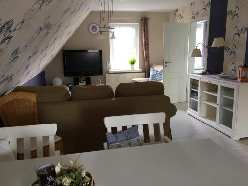 a living room with a couch and a tv at Gästehaus Schmidt in Boltenhagen