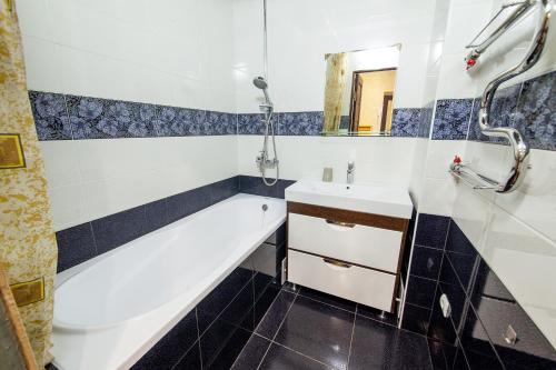 ein Badezimmer mit einer Badewanne und einem Waschbecken in der Unterkunft Panorama 22/2 in Krasnodar