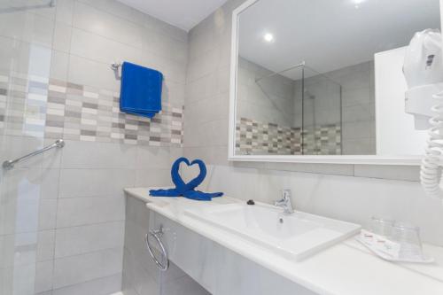 a bathroom with a sink and a blue ribbon at Vista Oasis in Maspalomas