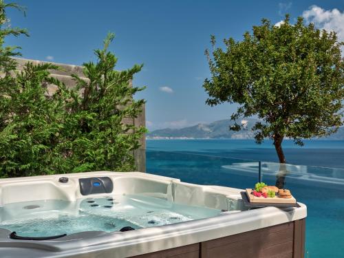 a bath tub with a view of the ocean at Avra Luxury Villa & Spa in Keri