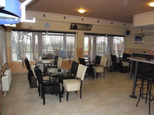 - une salle à manger avec des tables, des chaises et des fenêtres dans l'établissement Prenociste Denis, à Velika