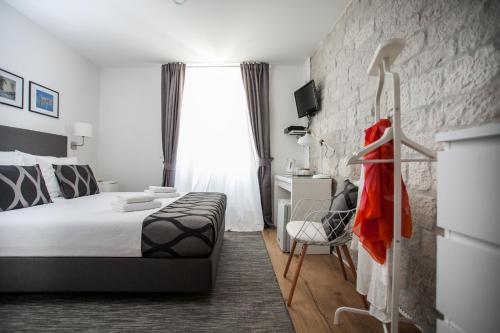 een slaapkamer met een bed en een bakstenen muur bij Villa Ivanka in Trogir