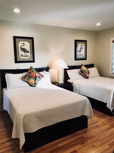 two beds in a hotel room with two lamps at Harborside Motel & Marina in Key West