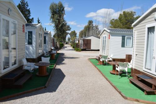 a row of houses with chairs and tables on a street at Camping Valencia el Saler in El Saler