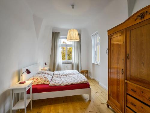 a white bedroom with a bed and a window at Villa Eschebach - Ferienwohnung in Dresden