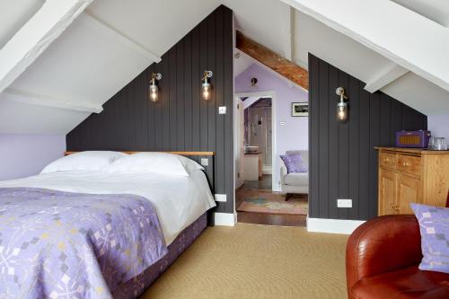 a bedroom with a bed and a chair at Harbourmaster Hotel in Aberaeron