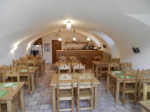 um restaurante com mesas e cadeiras de madeira numa sala em Auberge de la Motte em Les Combes