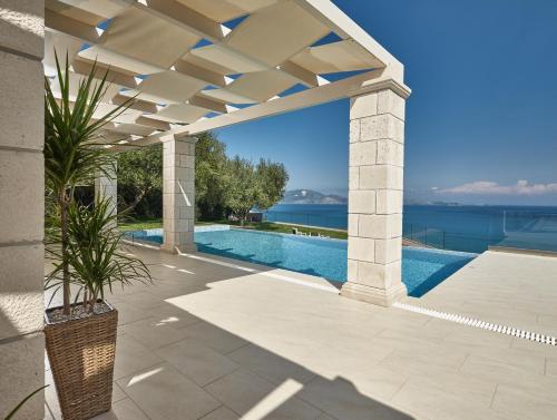 a patio with a swimming pool and a pergola at Avra Luxury Villa & Spa in Keri