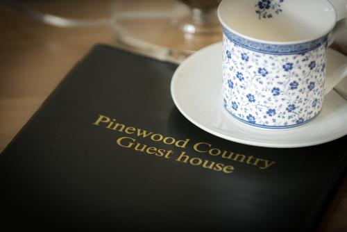 a coffee cup on a guest house book at Pinewood Country House in Leuchars