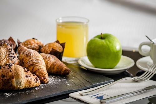 a tray of food with an apple and pastries on a table at Eurostars Roma Aeterna in Rome