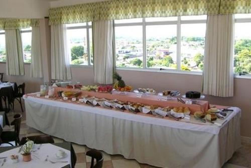 a long table with food on it in a room with windows at Hotel Presidente in Uruguaiana