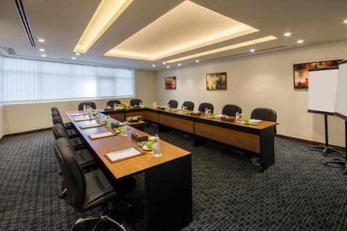 a conference room with a long table and chairs at Golden Tulip Media Hotel in Dubai