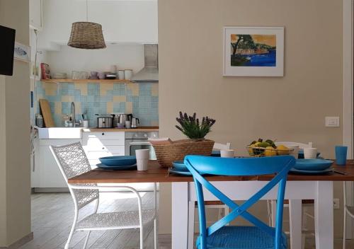 a kitchen with a wooden table with blue chairs at Romeo & Juliette in Monterosso al Mare