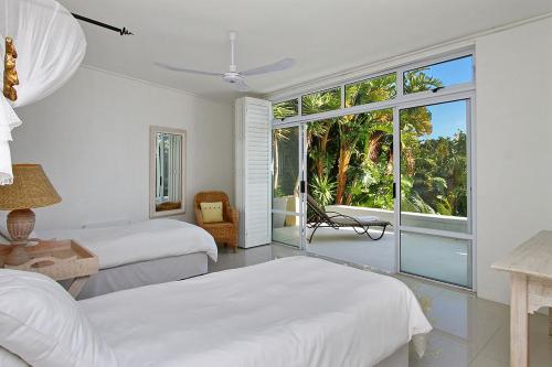 Msangasanga Villa في كيب تاون: غرفة نوم بيضاء مع سريرين ونافذة