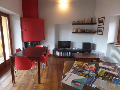 a living room with a table and red chairs at Casa del Gelsomino in Stresa