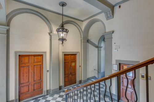 a hallway with two wooden doors and a staircase at Cherubini Palace Thematic Apartment in Florence