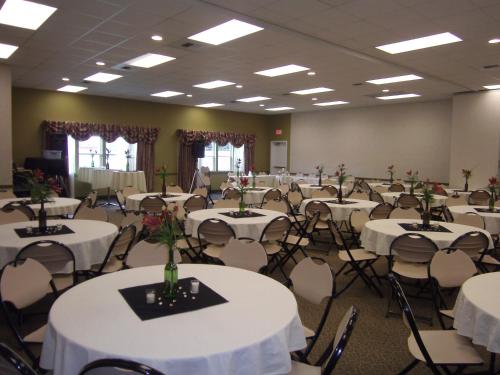 a banquet hall with white tables and chairs at Stay Beyond Inn & Suites in Elma