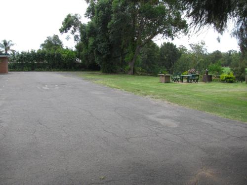 an empty parking lot with a picnic table in a park at The Wayfarer Motel in Muswellbrook