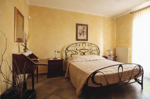 a bedroom with a bed and a desk and a bed sidx sidx sidx at Ca' Colomba in San Damiano dʼAsti