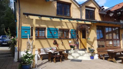 un bâtiment avec des tables et des chaises devant lui dans l'établissement Gästehaus-Einkehr, à Oberreute