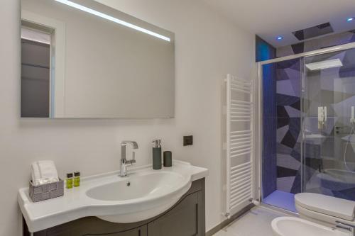 a white bathroom with a sink and a shower at Cherubini Palace Thematic Apartment in Florence