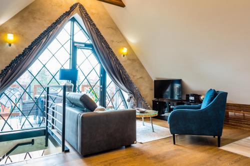 a living room with a couch and a large window at Norweska Dolina Family&Pet-friendly Resort in Szklarska Poręba