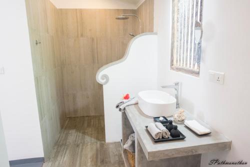 a bathroom with a sink on a counter next to a shower at South House-Weligama in Weligama
