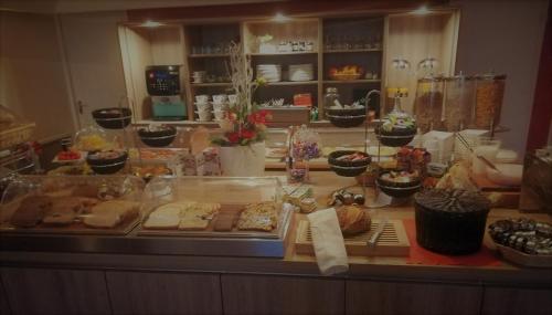 a counter with many different types of bread and pastries at Hotel van Dijk in Kampen