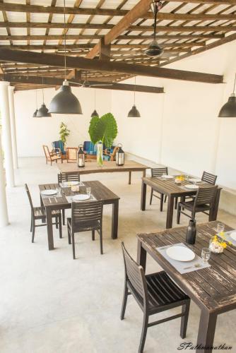 a dining room with wooden tables and chairs at South House-Weligama in Weligama