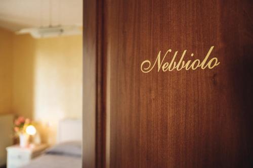a wooden door with the name of a hotel room at Ca' Colomba in San Damiano dʼAsti
